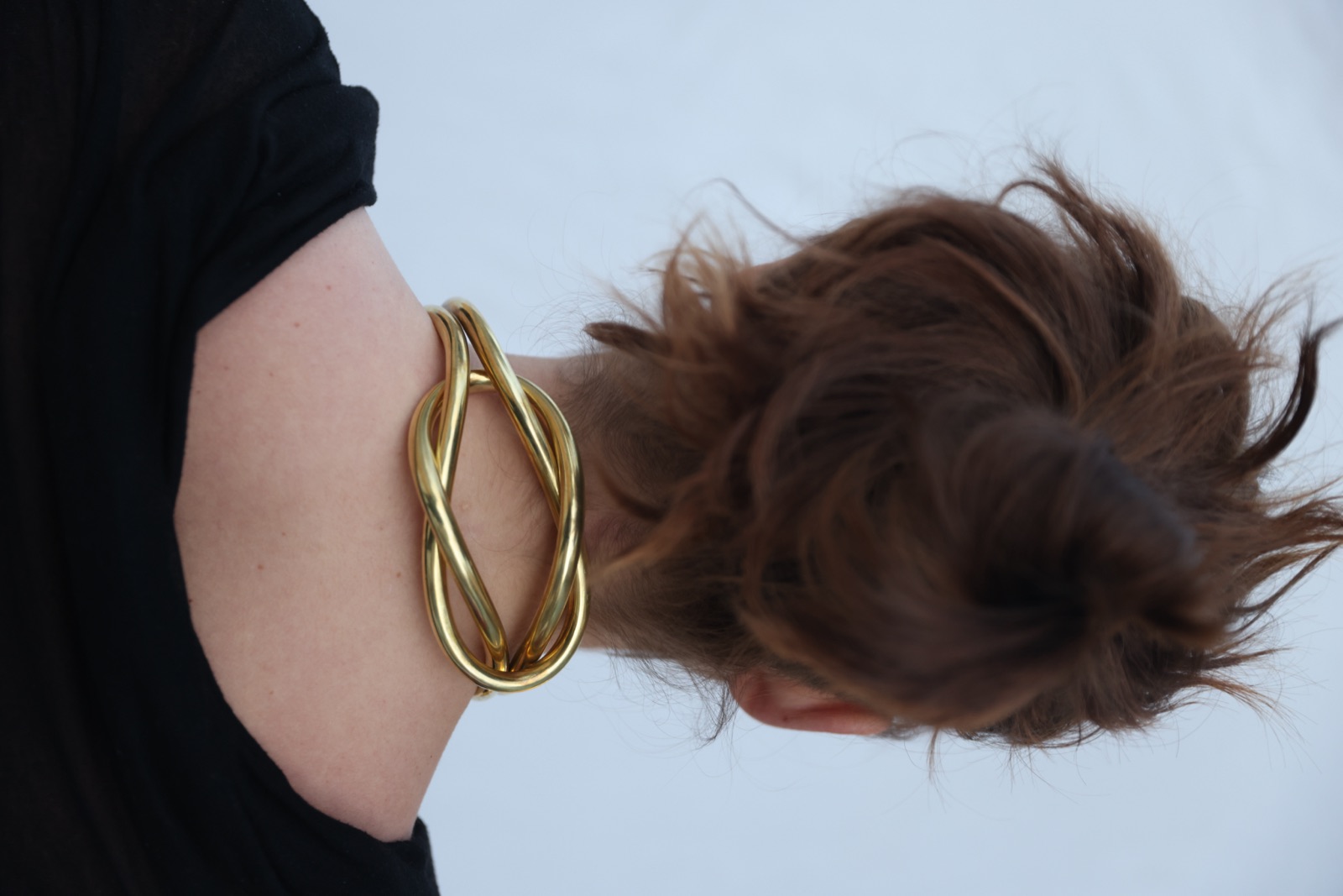 Knotted brass neckpiece worn at the nape