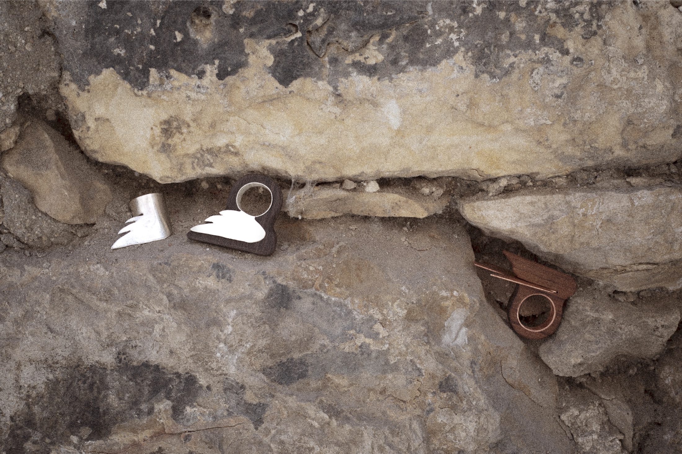 Angel Collection rings resting in the crevices of an ancient stone wall