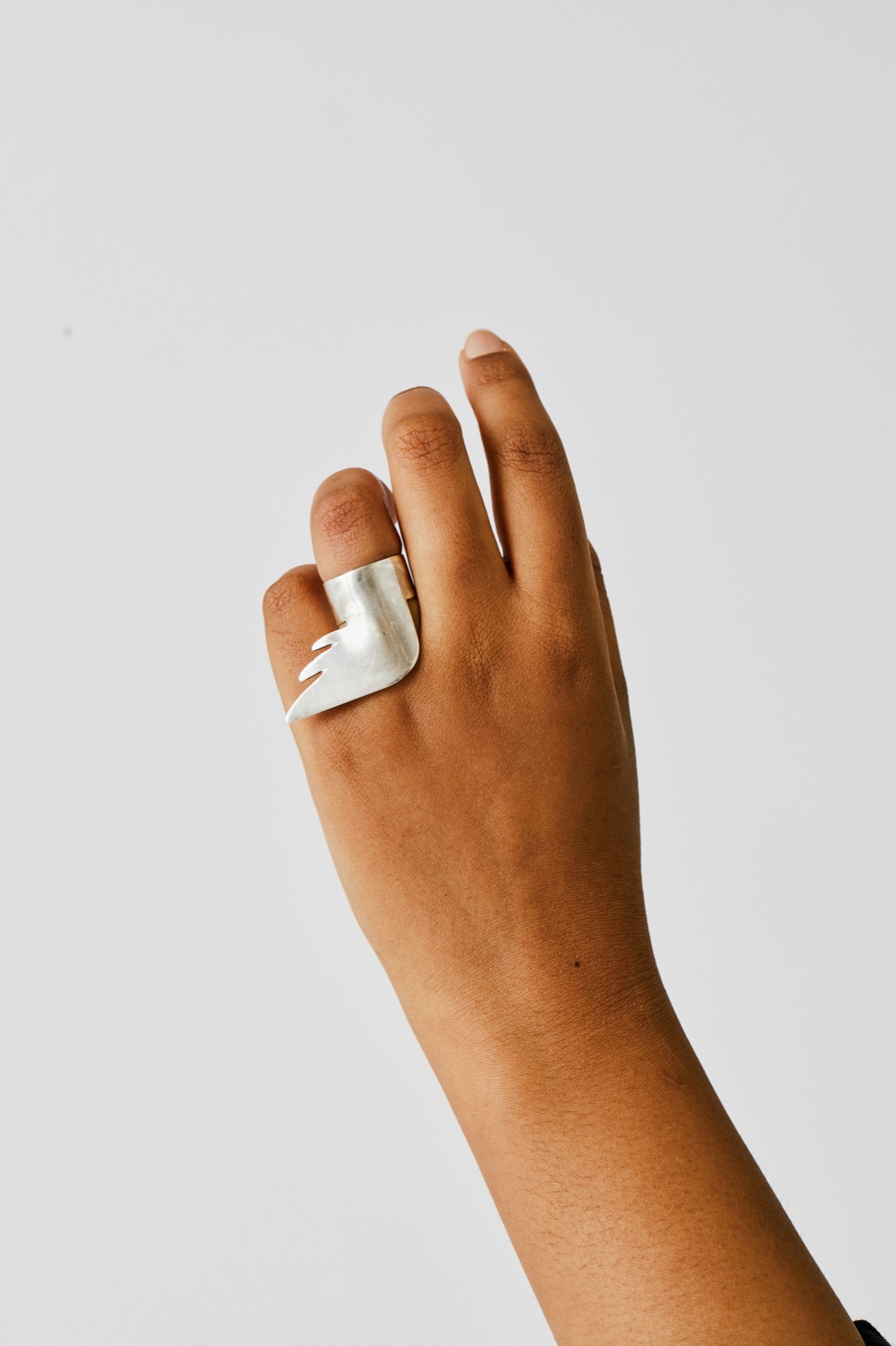 Silver wing ring on an outstretched hand
