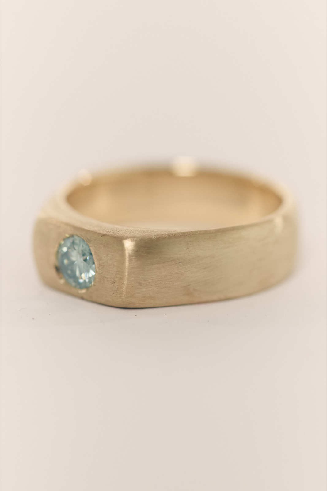 Brushed gold ring set with a pale blue stone