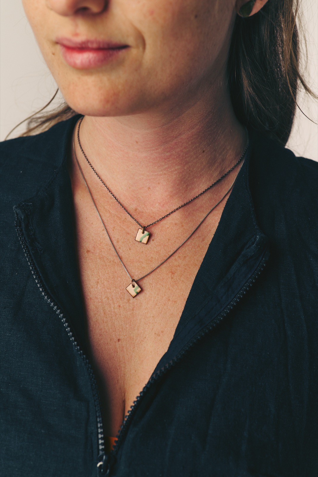 Two delicate pendants on fine dark chains
